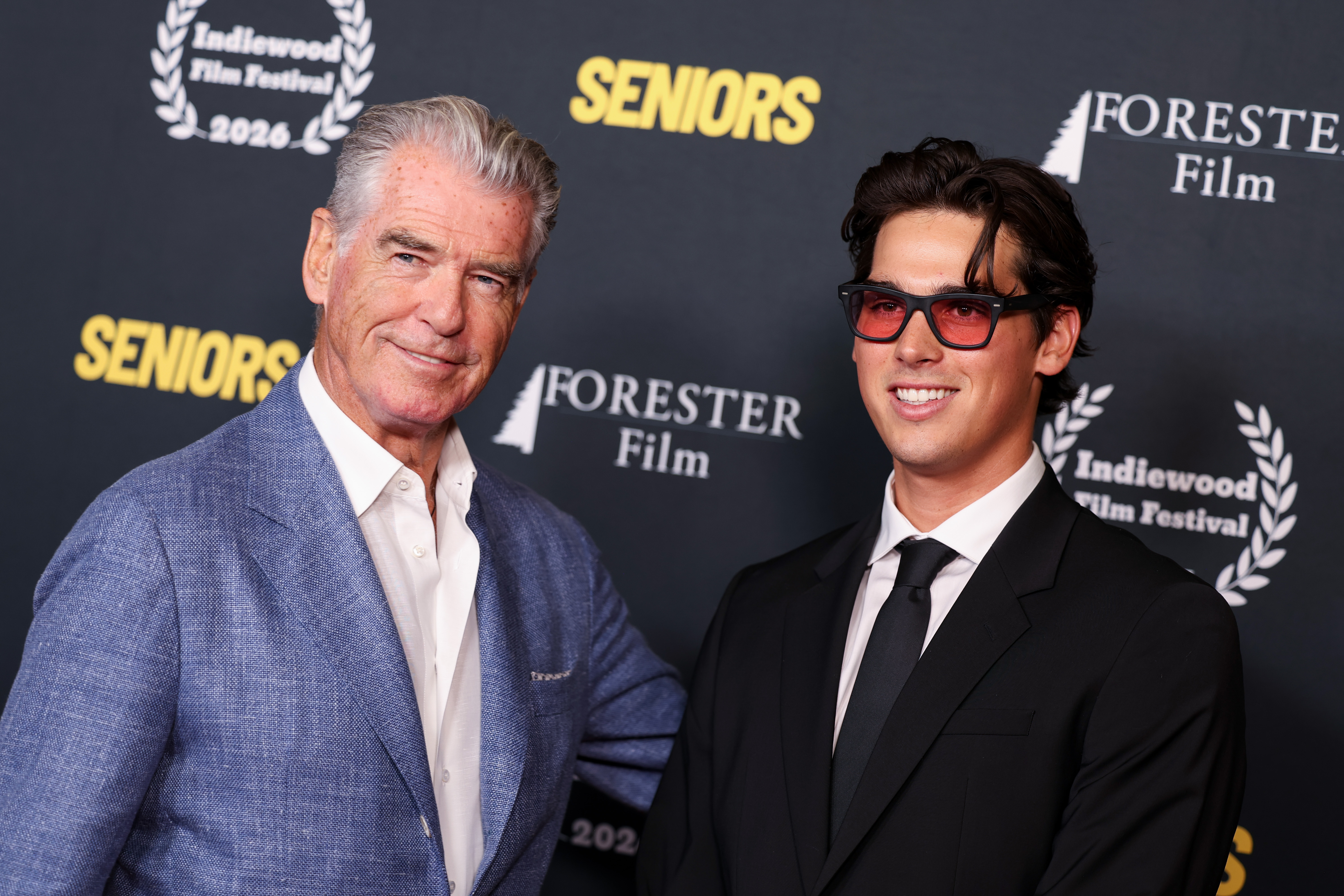 Pierce and Paris Brosnan posed side by side for a father-son portrait at the TCL Chinese Theatre. Paris wore his red-tinted glasses with a black suit and tie, an accessory that later became a specific talking point among Facebook commenters. | Source: Getty Images