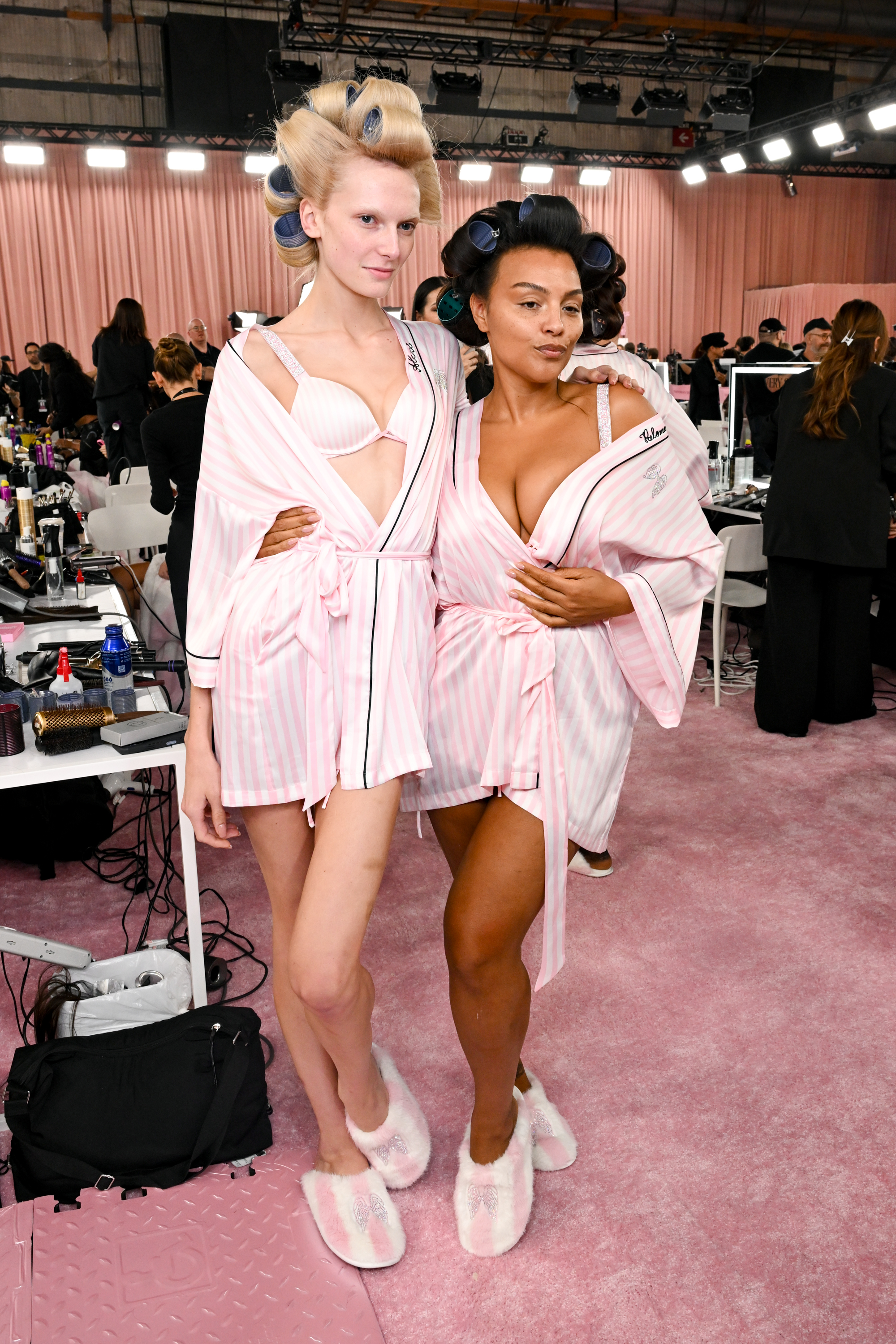 Alex Consani and Paloma Elsesser with rollers and in pink robes backstage at the 2026 Victoria's Secret Fashion Show on October 18, 2026 | Source: Getty Images