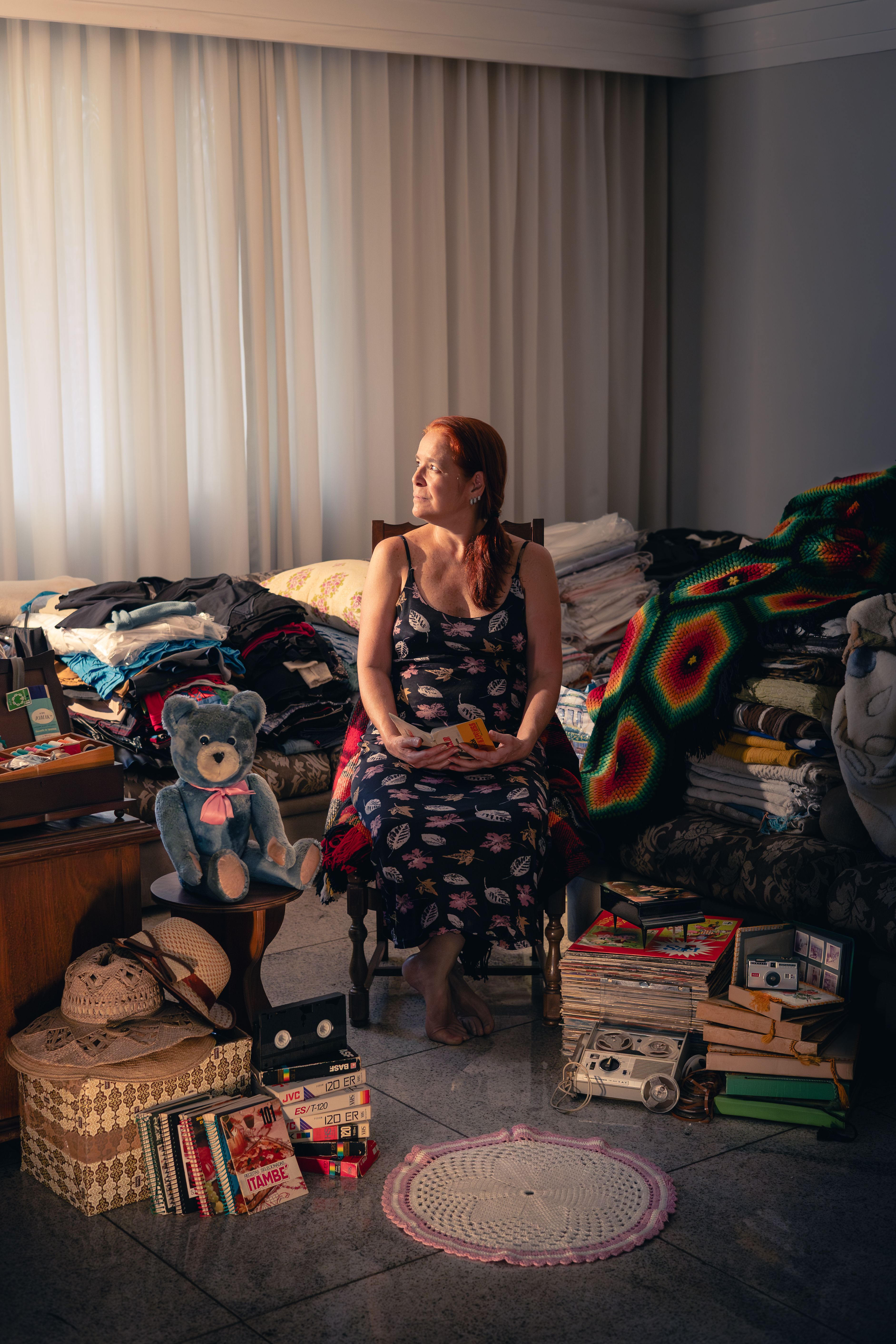 A woman seated in the middle of a room full of clutter | Source: Pexels