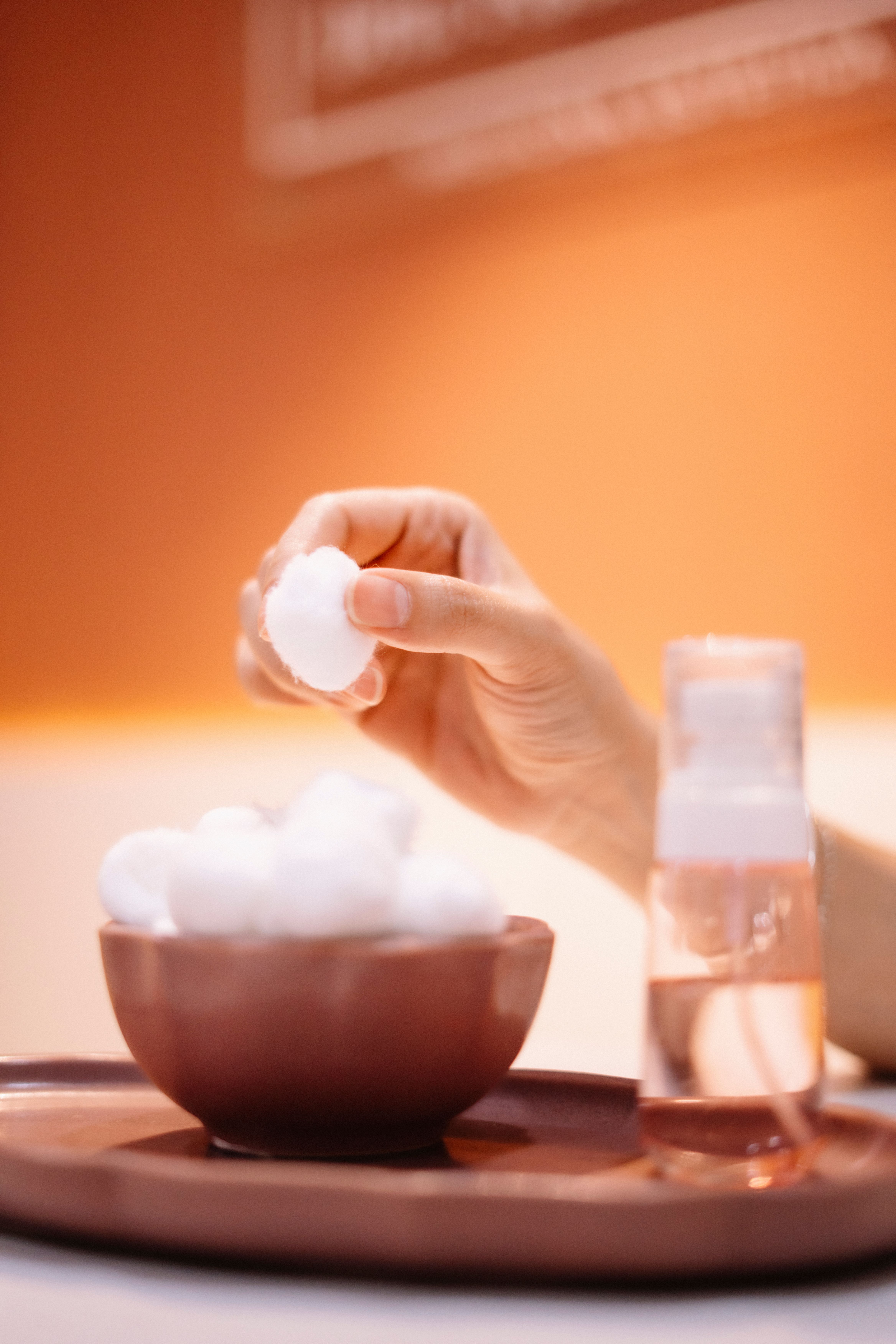 Hand picking from a bowl of cotton balls | Source: Pexels