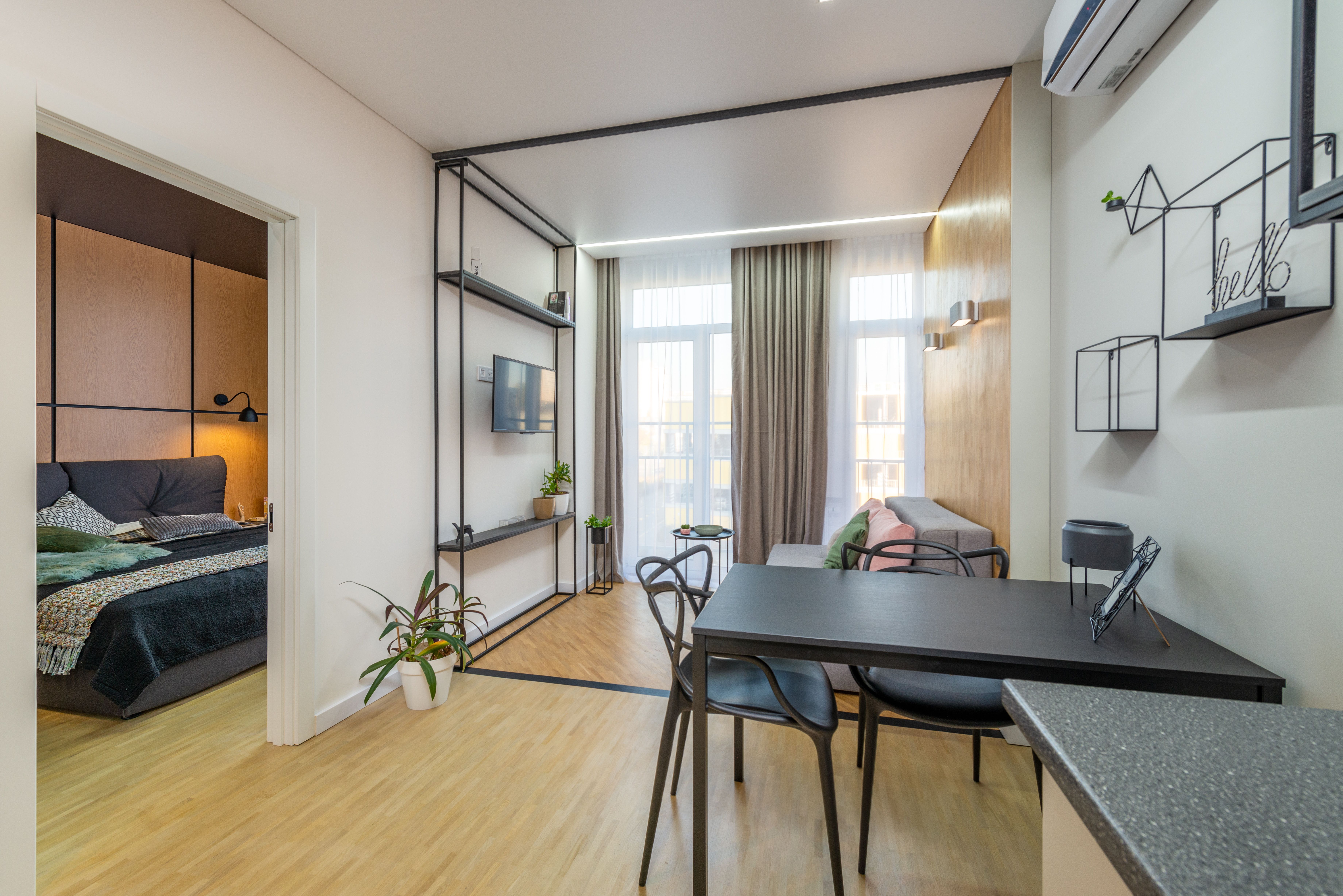 A modern apartment features an open-plan living and dining area with a separate bedroom. | Source: Pexels