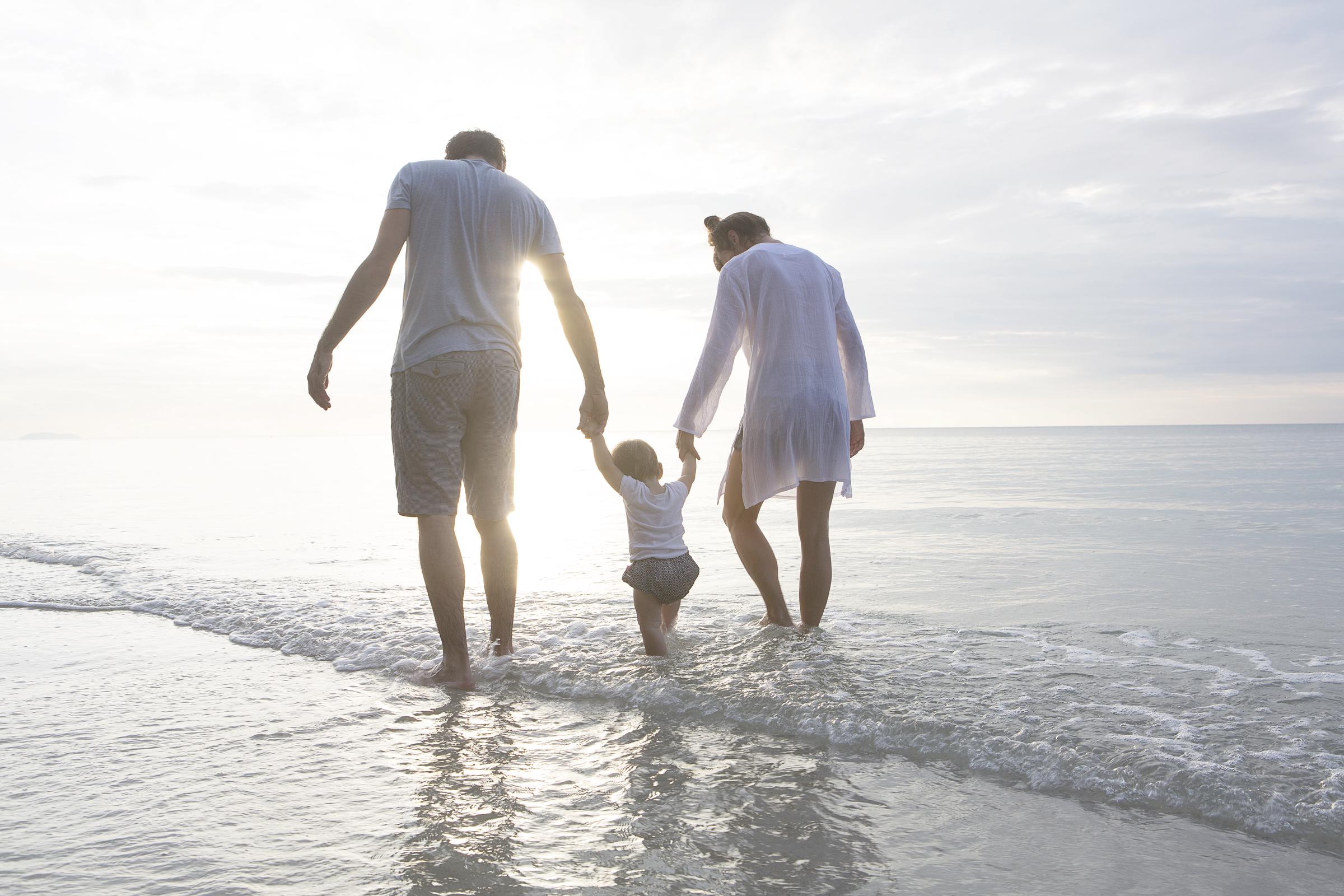 A young family enjoying a walk on the beach | Source: Getty Images