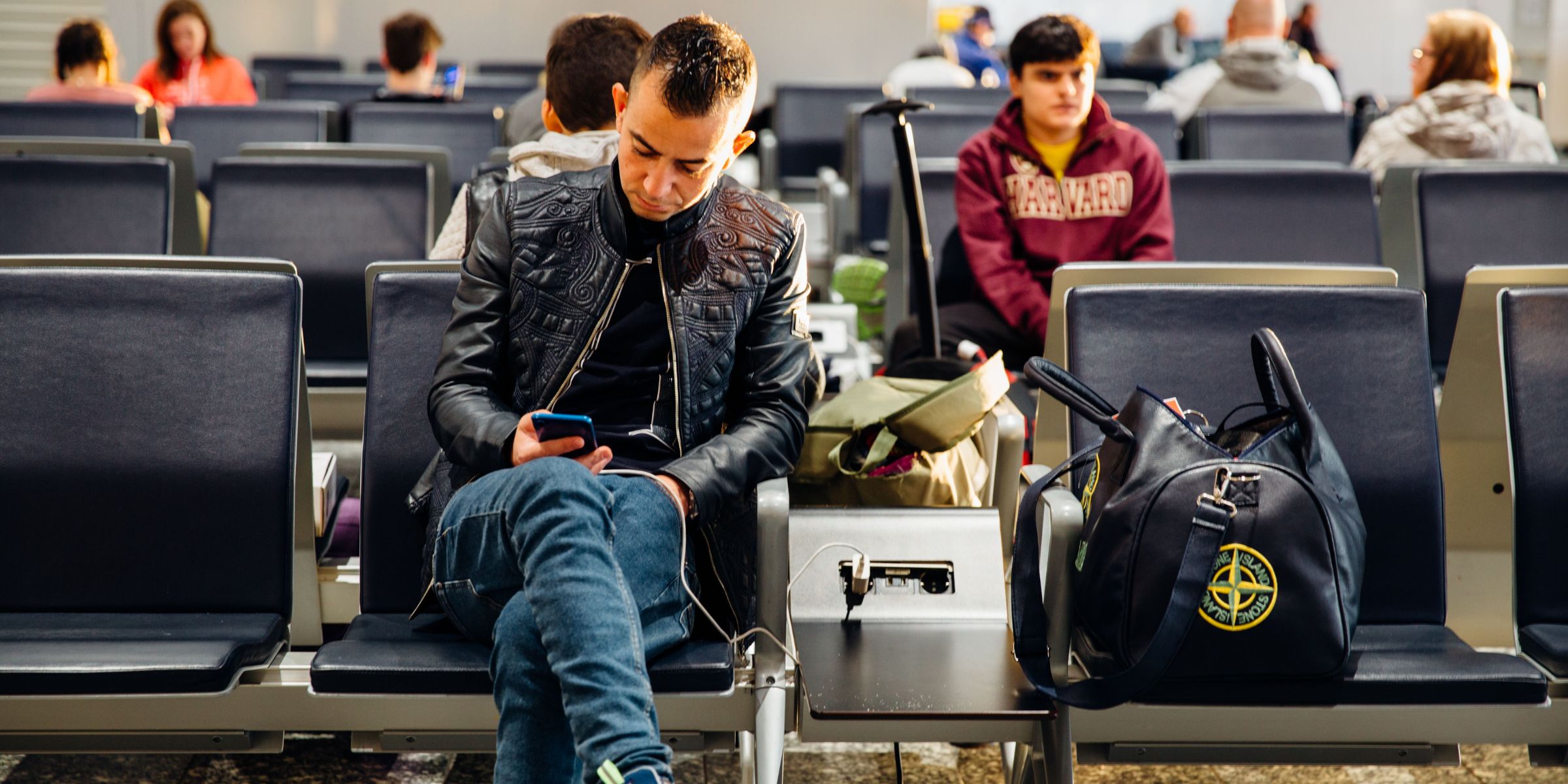 A man charging his phone at the airport | Source: Pexels