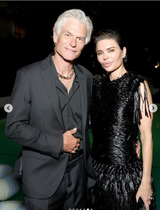 Lisa Rinna and Harry Hamlin pose together during Emmy weekend, with Rinna's glossy black fringe gown contrasting with Hamlin's monochromatic suit and silver hair. | Source: Instagram/lisarinna