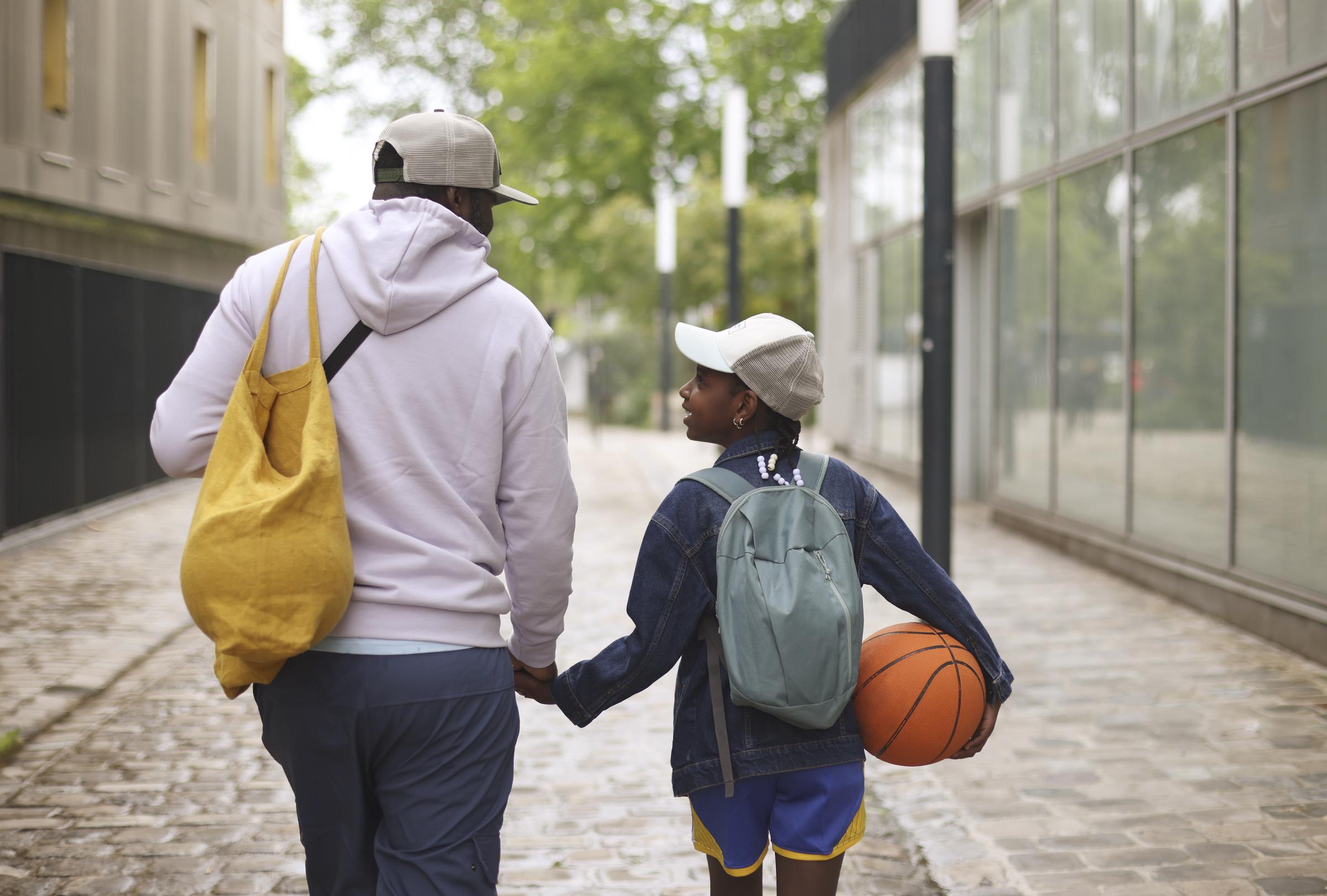A father and his daughter on their way to play basketball | Source: Getty Images