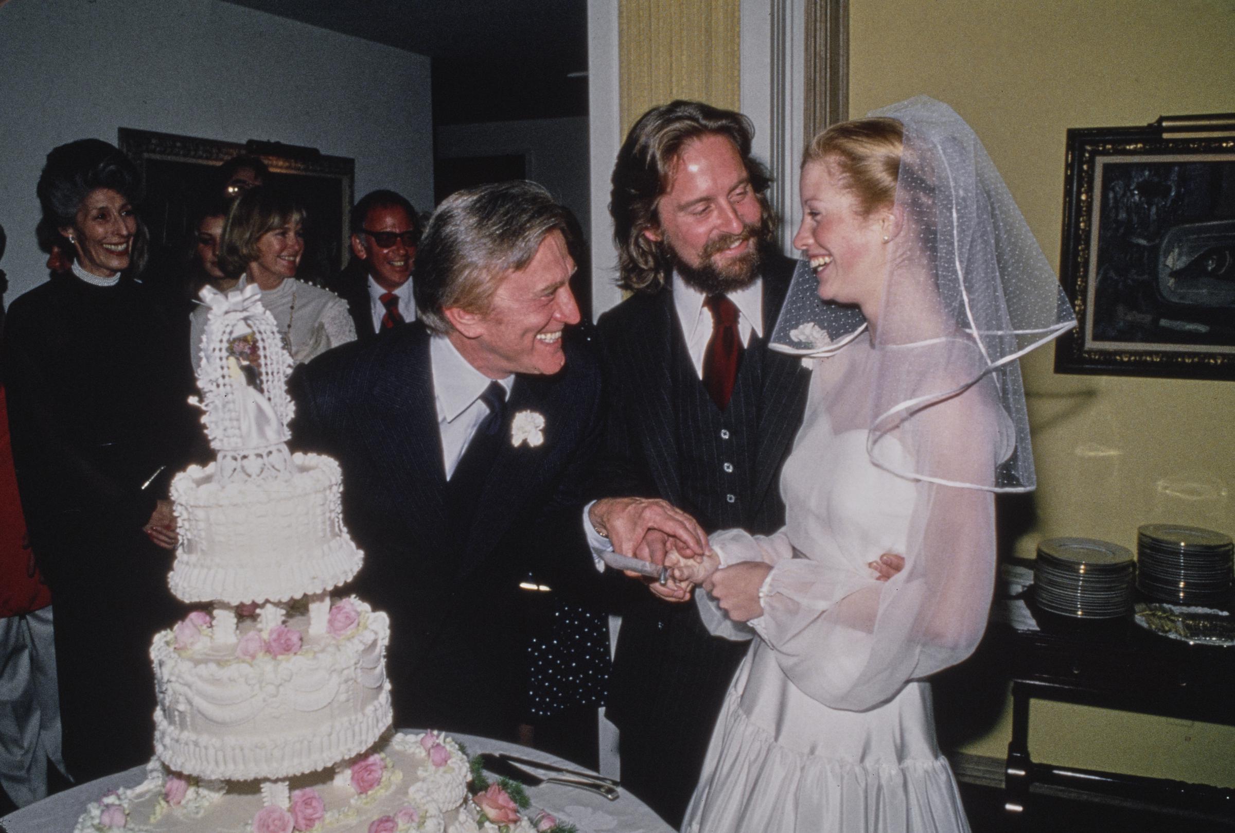 Michael Douglas and Diandra Luker cut their wedding cake at their reception at the Beverly Wilshire Hotel in Beverly Hills, California, on March 20, 1977. Their marriage would later become central to Douglas’ revelations about romances he had while they were still together. | Source: Getty Images