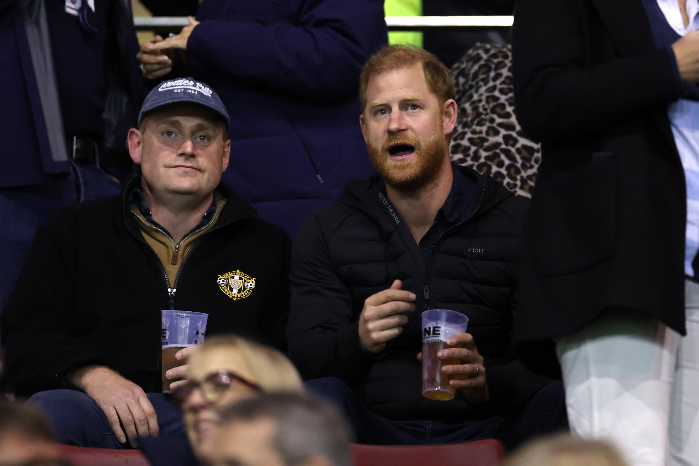 Prince Harry leans forward in his seat while watching the Gallagher PREM 2026/2027 match between Leicester Tigers and Gloucester Rugby on October 9, 2026, in Leicester, England. He holds a plastic cup as spectators around him watch the game. | Source: Getty Images