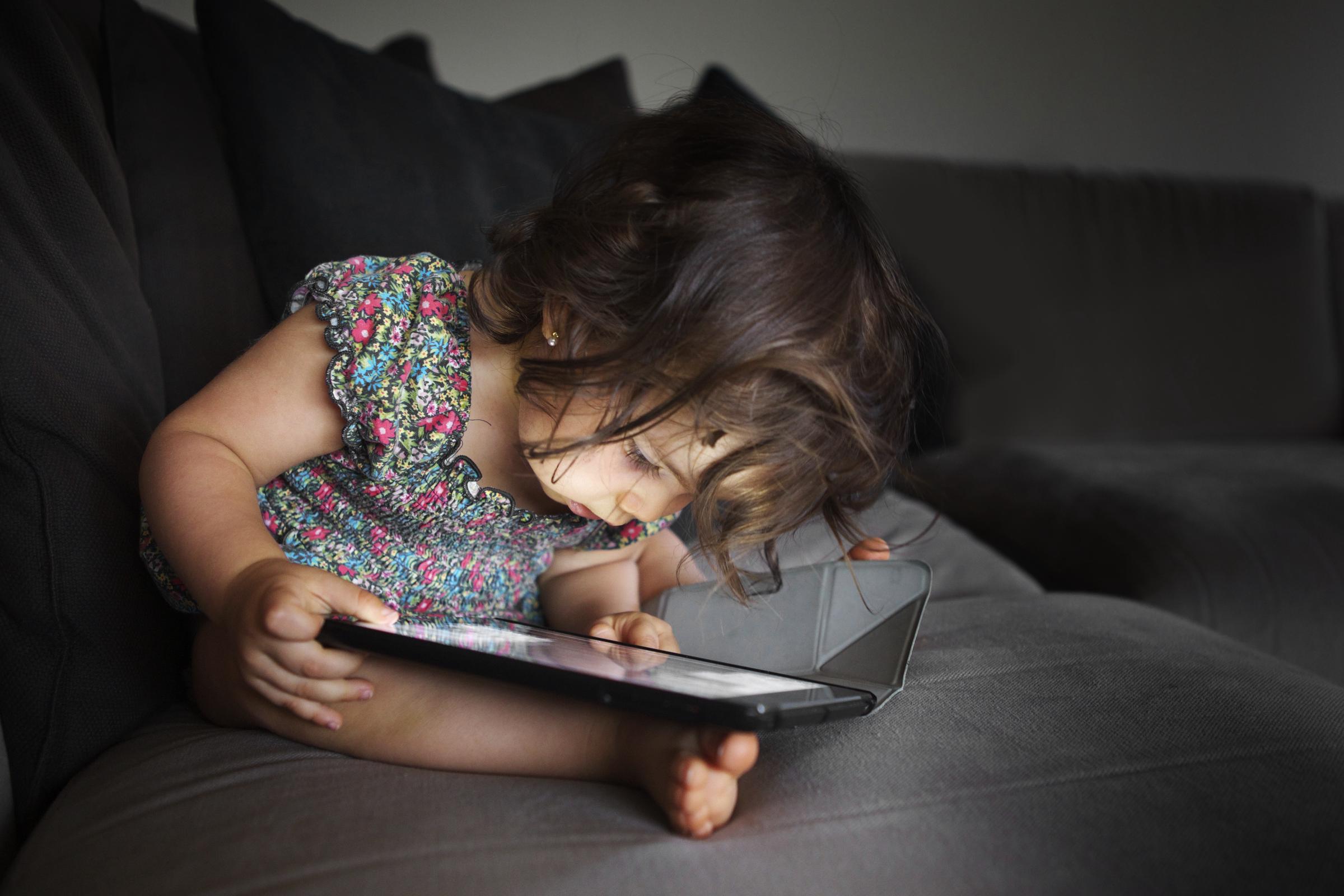 A little girl watching a video on a digital tablet | Source: Getty Images