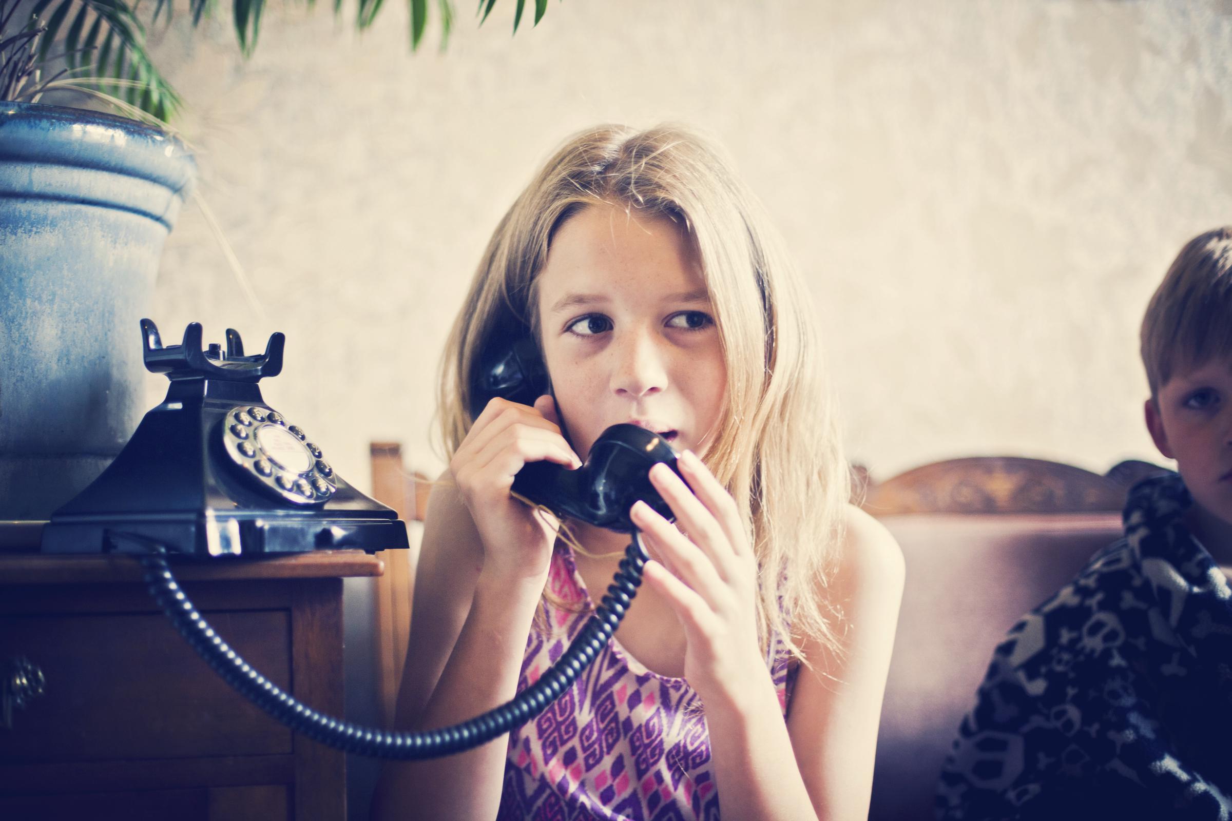 A girl talking to someone on a landline telephone | Source: Getty Images