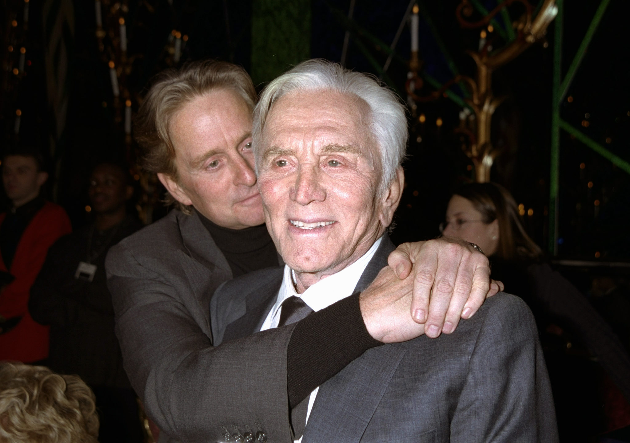 Kirk Douglas received a big hug from his son, Michael Douglas, at a party in the Russian Tea Room following the premiere of Kirk’s movie Diamonds. Michael later revisited his relationship with Kathleen Turner in his memoir, prompting her lighthearted response to the decades-old revelation. | Source: Getty Images
