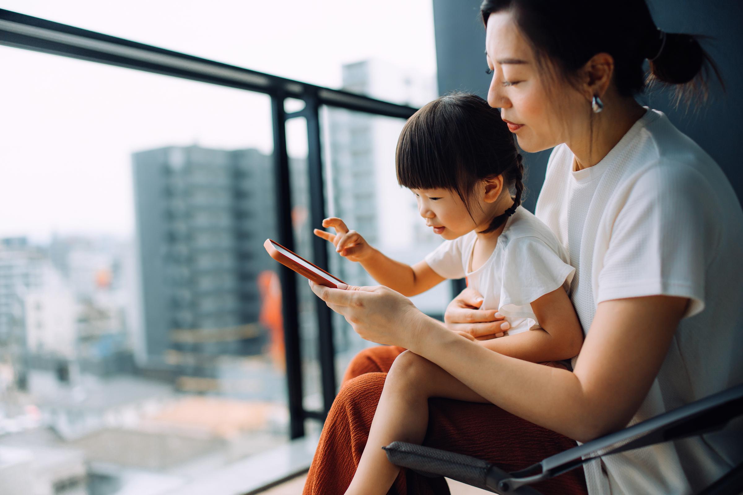 A mom and daughter using smartphones together | Source: Getty Images