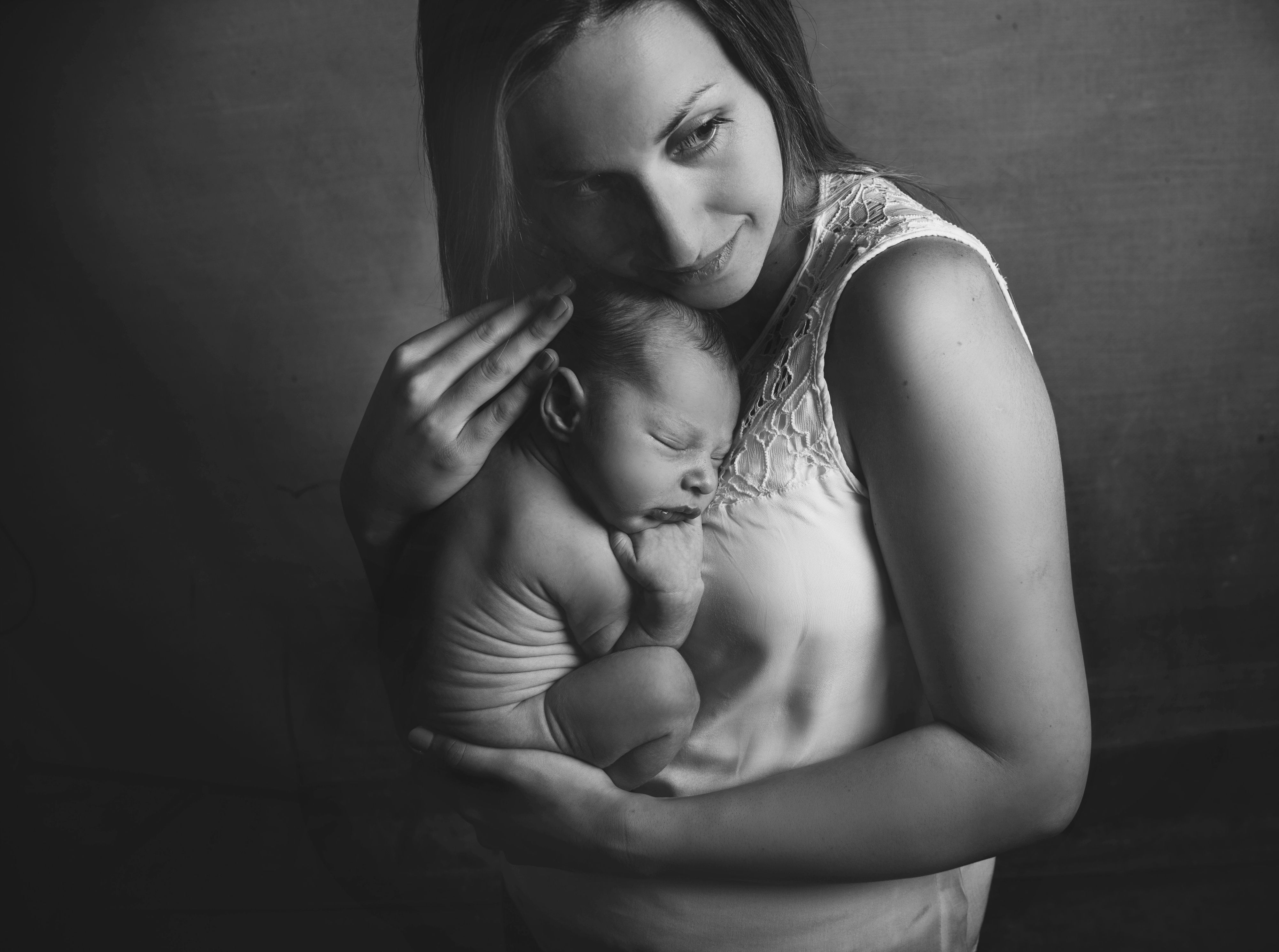 A mother holding her bare-skinned newborn baby close to her chest | Source: Pexels