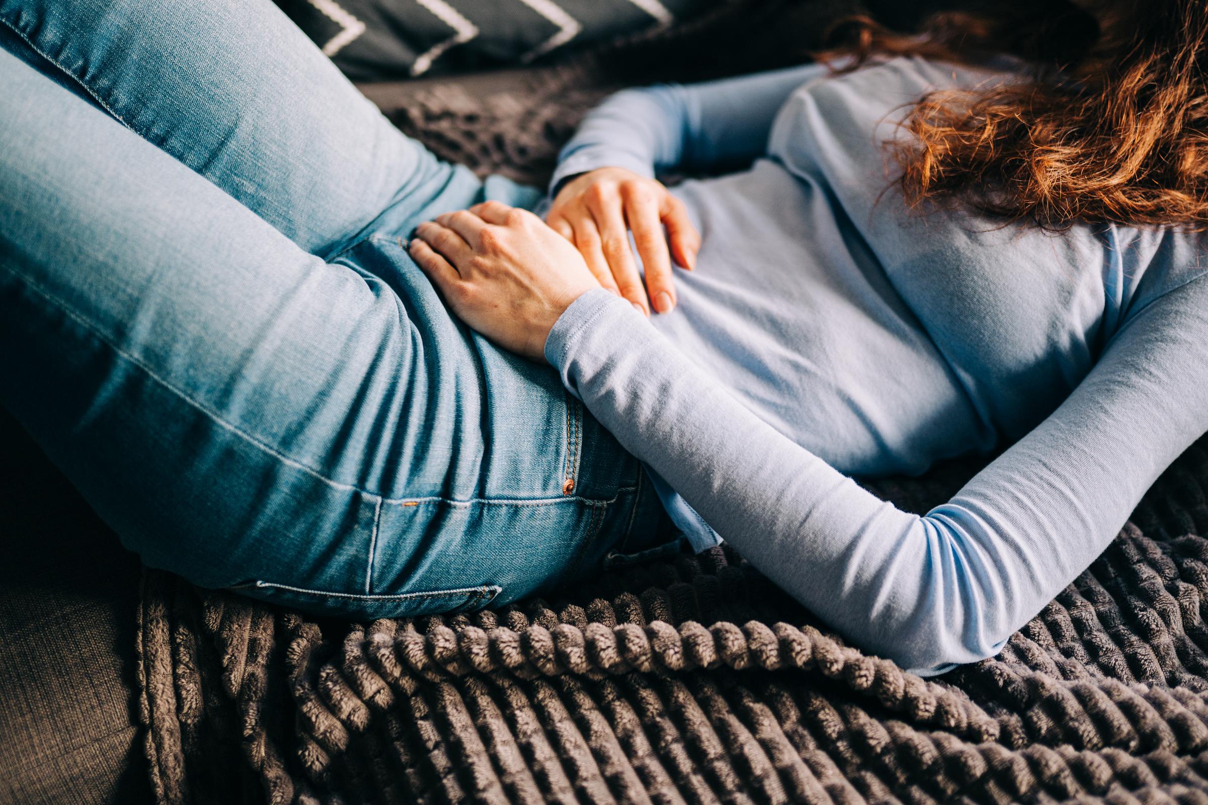 A woman struggling with stomach cramps | Source: Getty Images