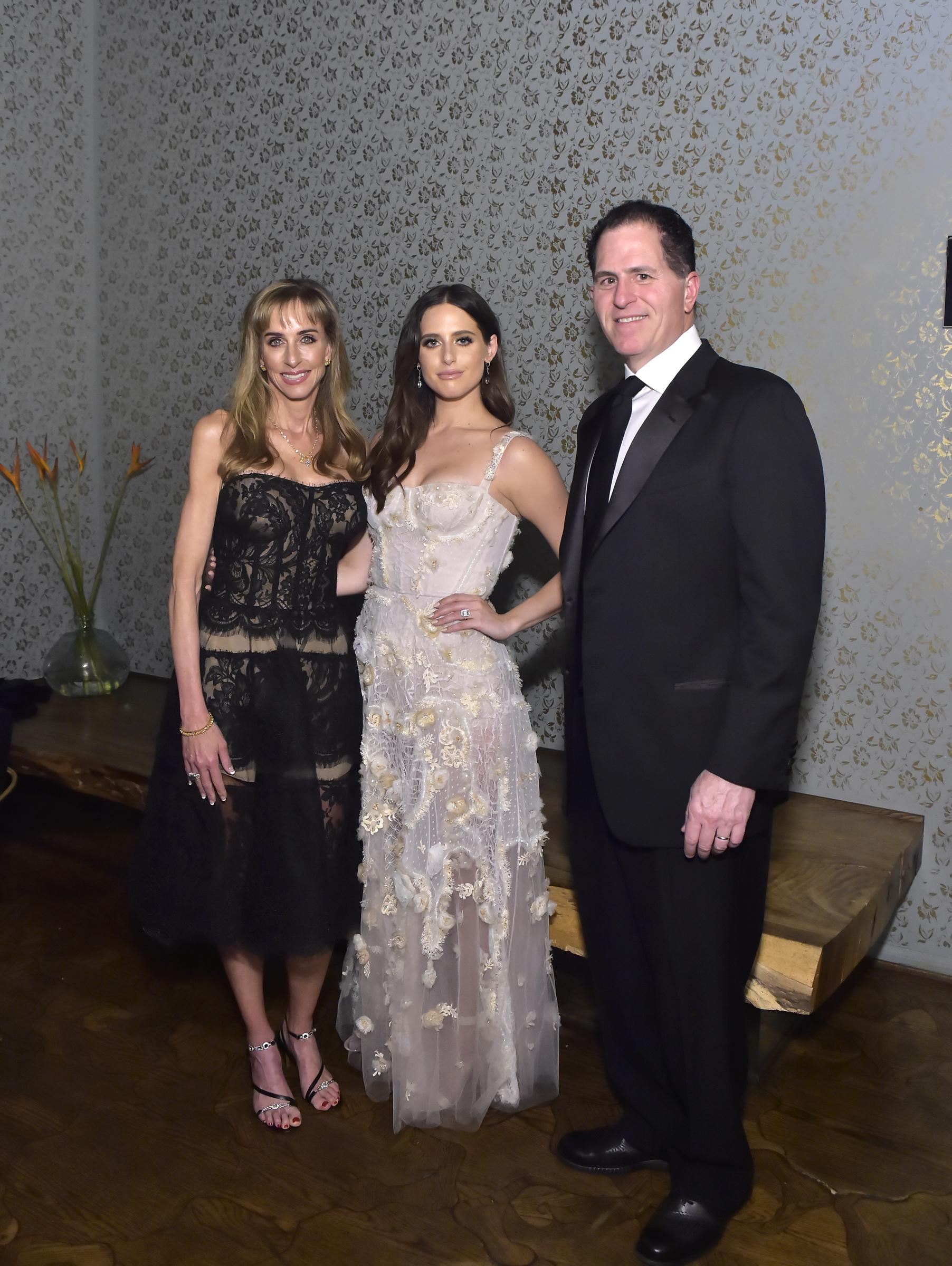 Susan Dell, Alexa Dell, and Michael Dell posed together at Alexa Dell and Harrison Refoua's engagement celebration at Ysabel in West Hollywood, California, on May 12, 2018. Susan wore a strapless black lace cocktail dress with ankle-strap heels and a delicate necklace, while the bride-to-be Alexa stood in the center wearing an ethereal embroidered gown, alongside Michael in a sharp black tuxedo and black tie. | Source: Getty Images