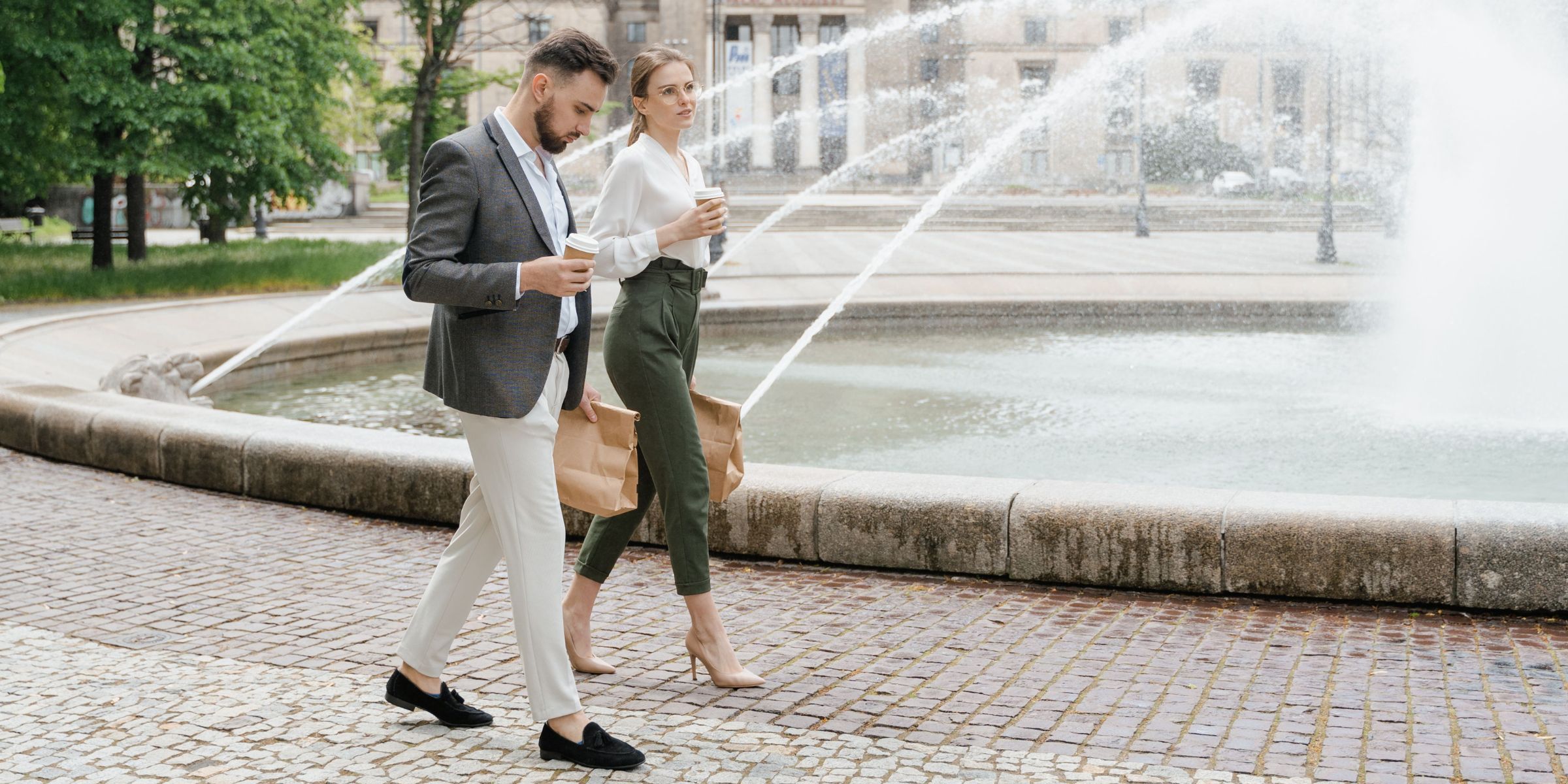 Two people walking while having coffee | Source: Pexels