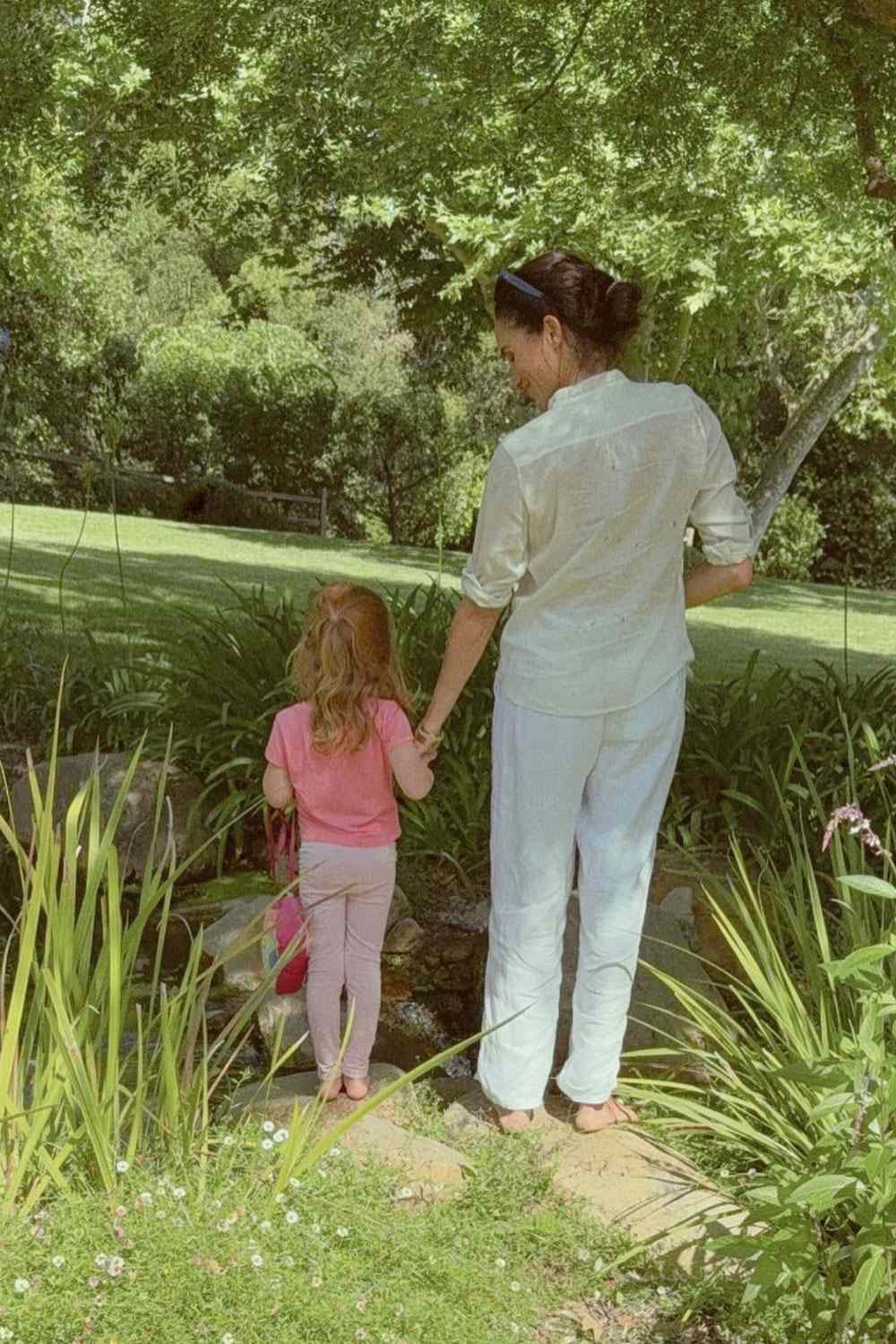A mother and daughter are seen holding hands in the garden, another quiet family moment shared from their everyday life away from public events and cameras. | Source: Meghan Markle’s Instagram
