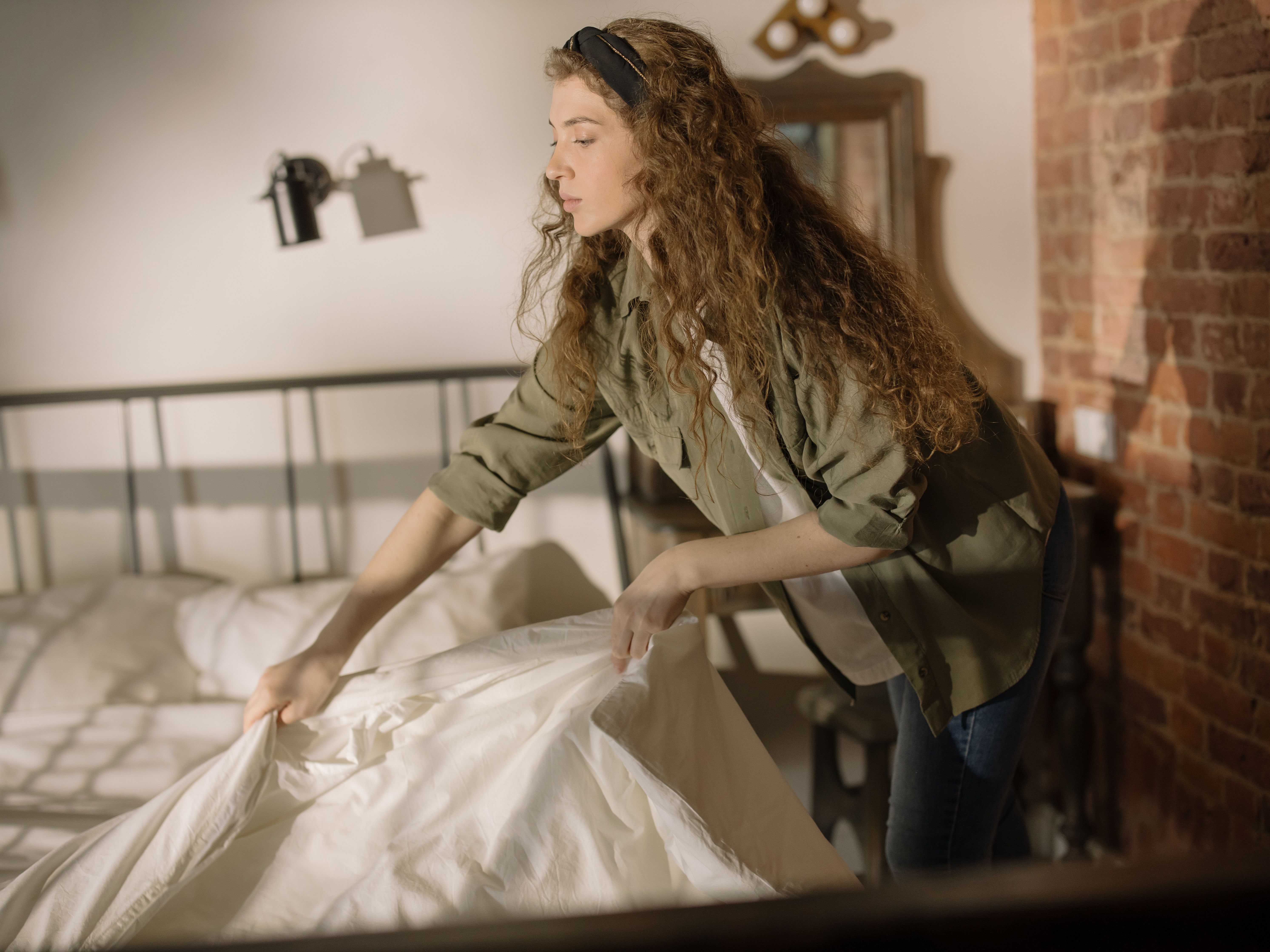 A woman stripping a bed | Source: Pexels