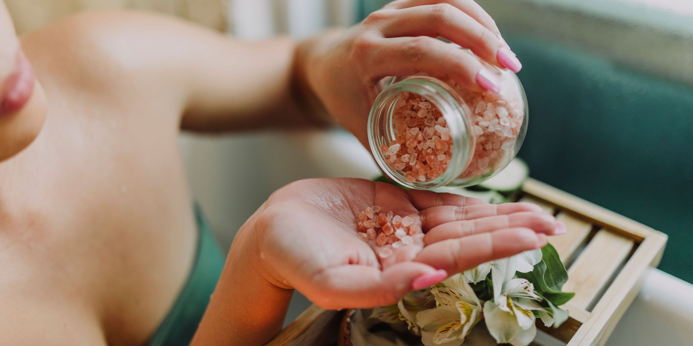 A woman pouring pink salt into her hand | Source: Pexels