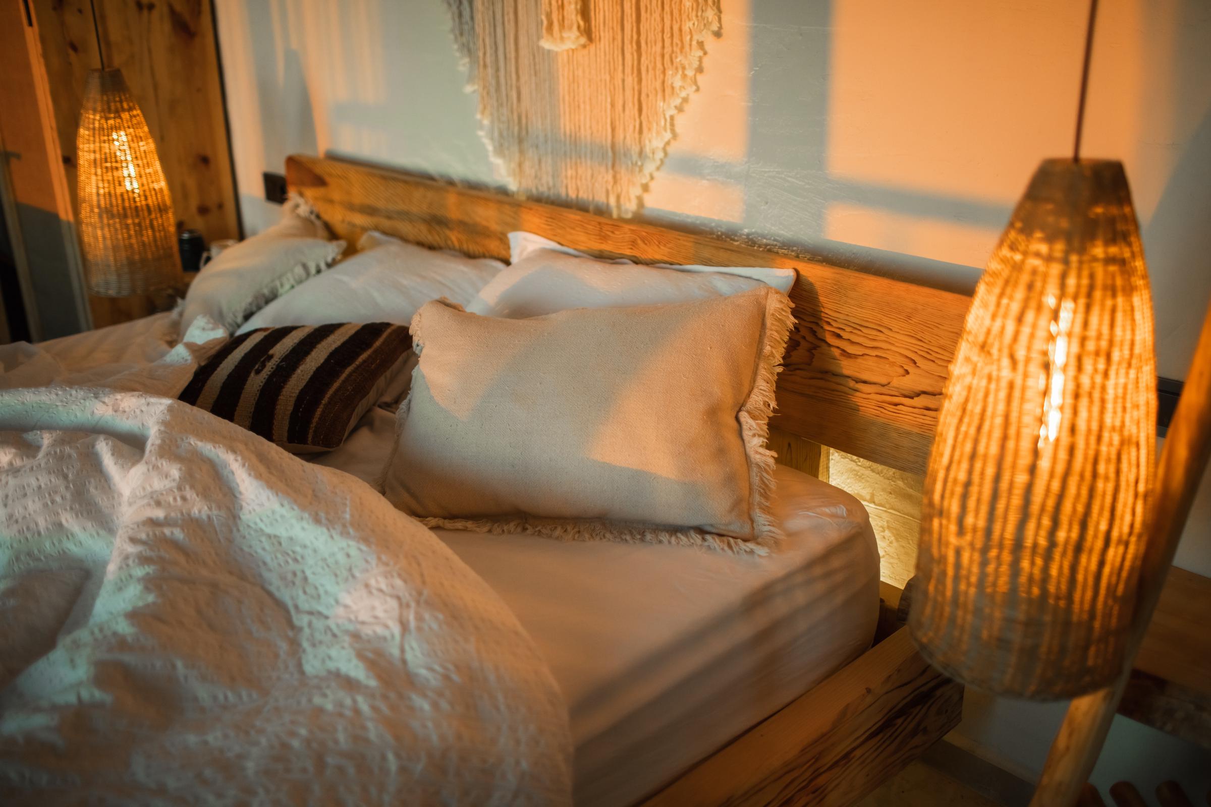 Handmade wicker lamps flanking a bed | Source: Getty Images