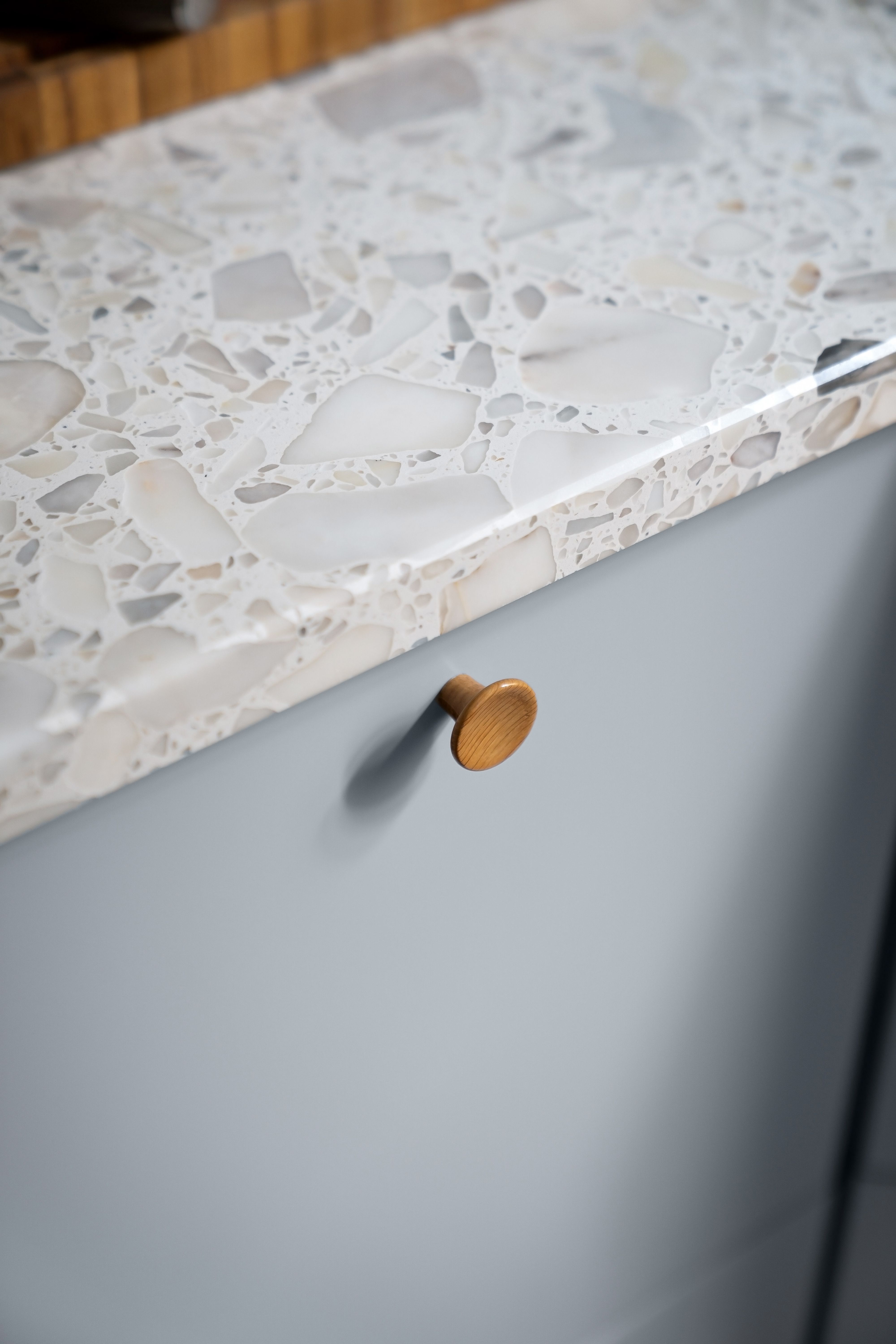 A close-up of a countertop and a cabinet with a wooden knob. | Source: Pexels