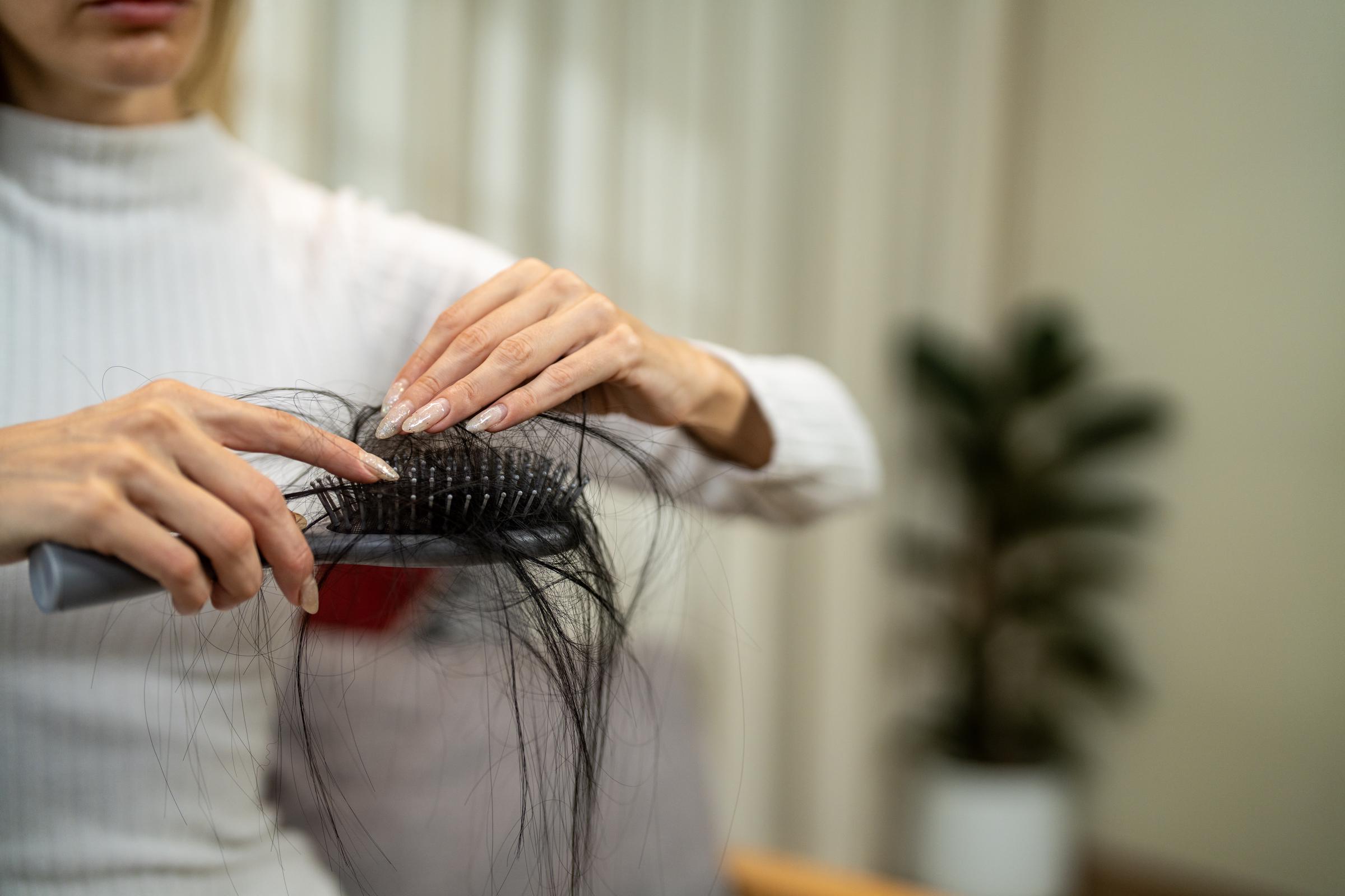 A woman cleaning her hair brush | Source: Getty Images