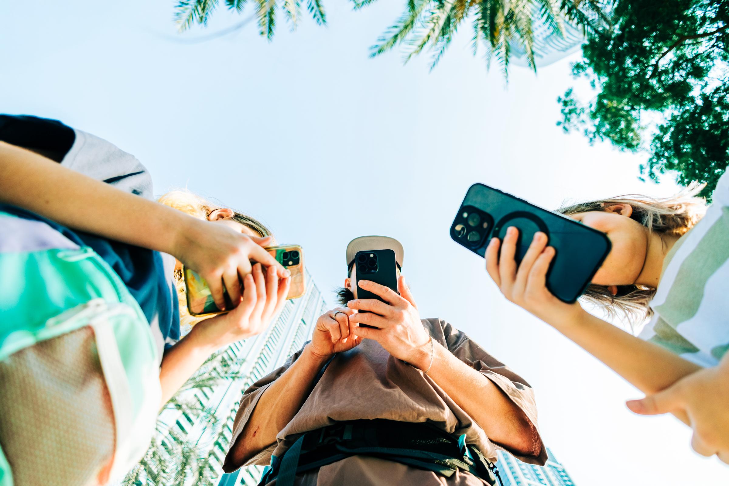 A group of people using smartphones outdoor | Source: Getty Images
