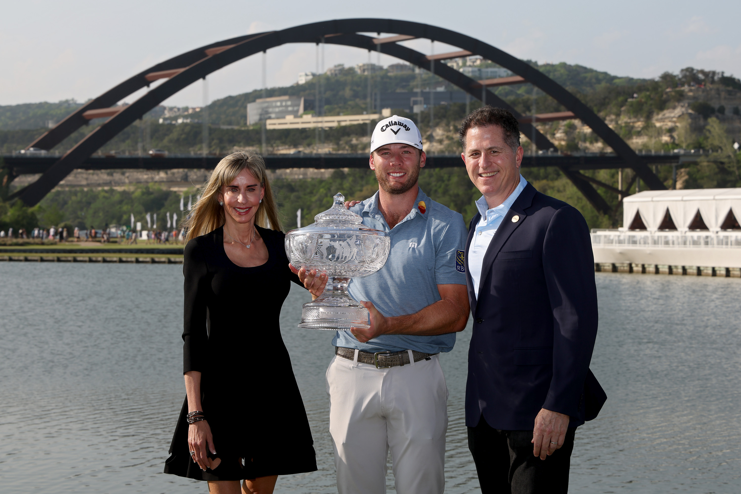 Susan Dell and Michael Dell pose alongside champion Sam Burns as he holds the crystal trophy following his victory at the World Golf Championships-Dell Technologies Match Play at Austin Country Club on March 26, 2023, in Austin, Texas. | Source: Getty Images