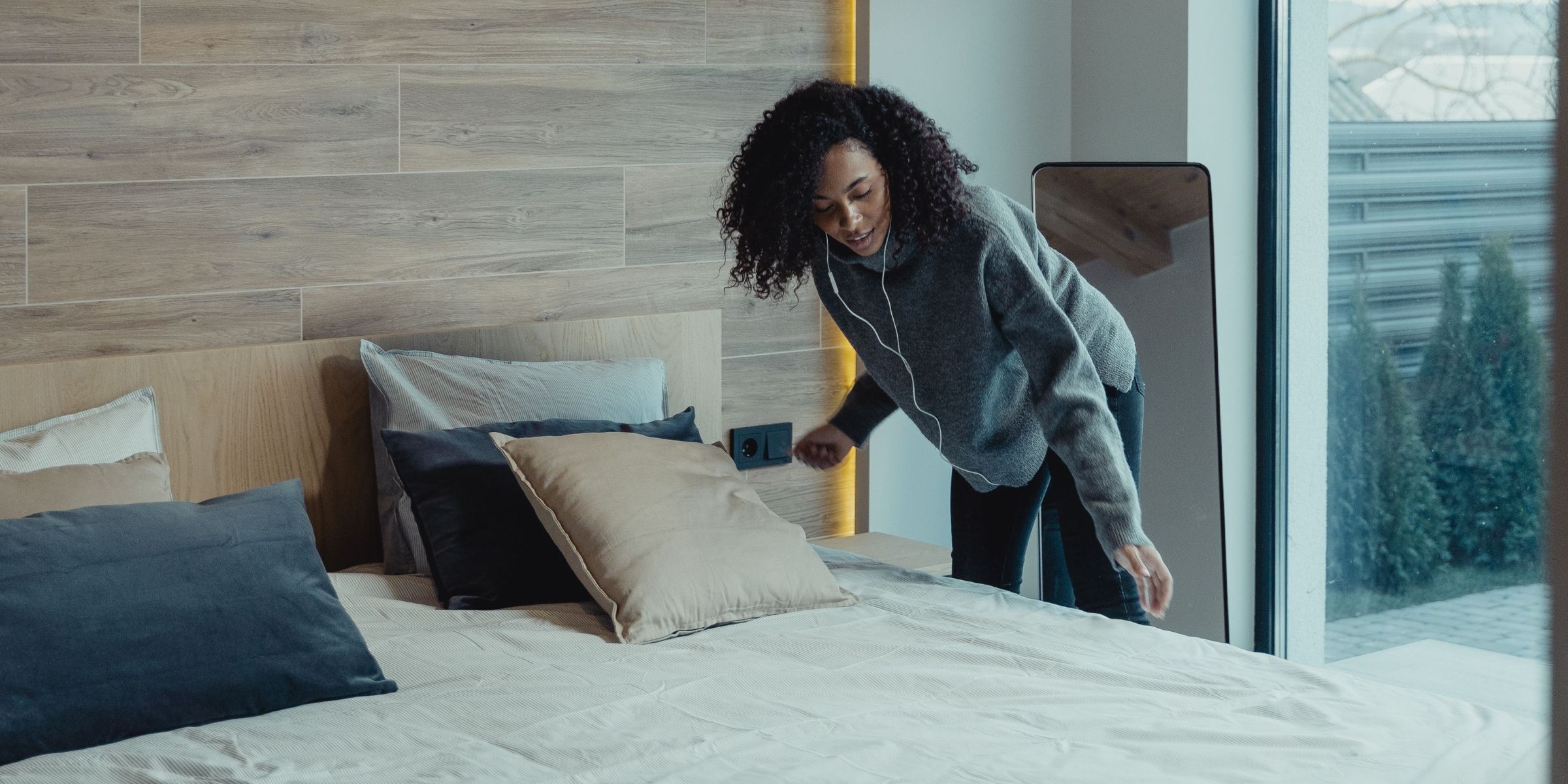 A woman fixing a bed | Source: Pexels