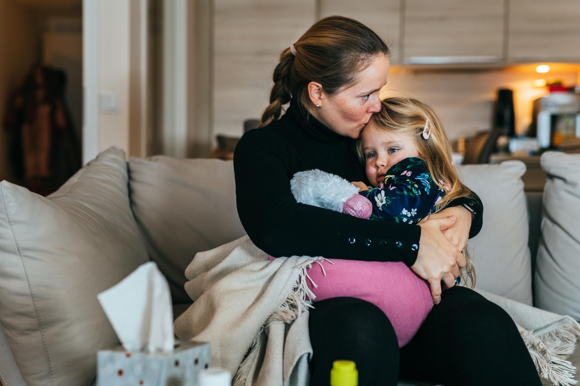 A mother embracing her daughter on a couch | Source: Getty Images